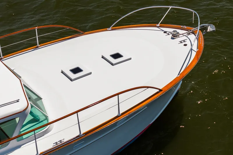 Slide: The Image of 1958 Rybovich 54 Yachtfish boat deck with wooden railings on water. - 4