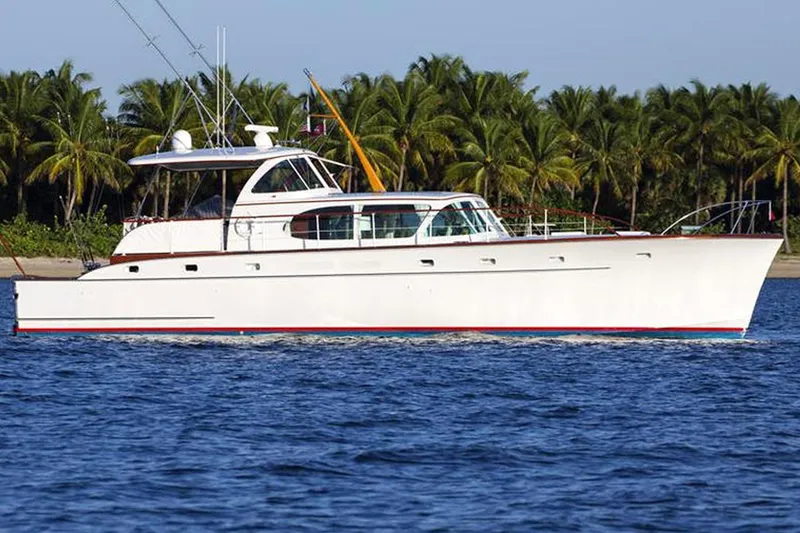 Slide: The Image of 1958 Rybovich 54 Yachtfish cruising near palm-lined shore. - 23