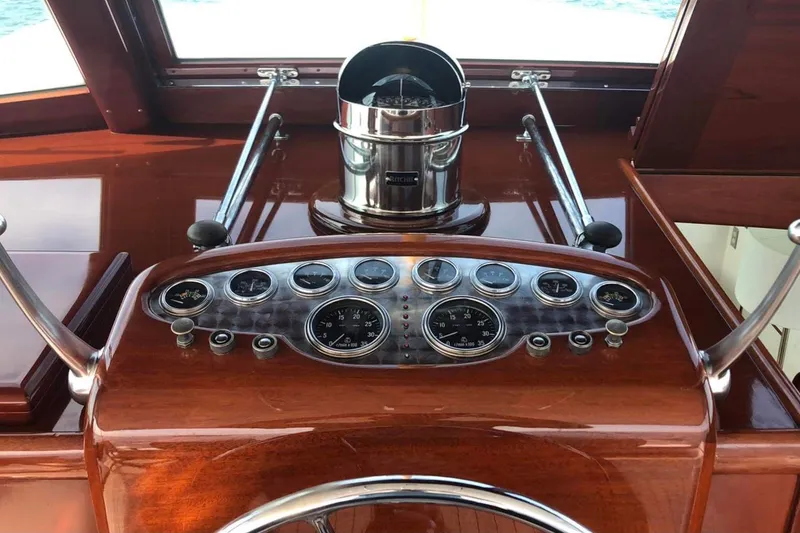 Slide: The Image of 1958 Rybovich 54 Yachtfish dashboard with classic gauges and polished wood finish. - 4