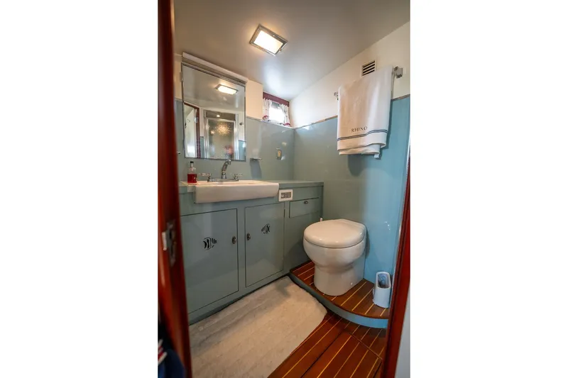Slide: The Image of Bathroom interior of 1958 Rybovich 54 Yachtfish, featuring sink, toilet, and wooden flooring. - 21