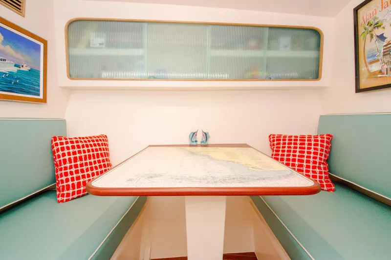 Slide: The Image of 1958 Rybovich 54 Yachtfish interior with teal seating, red pillows, and nautical decor. - 9