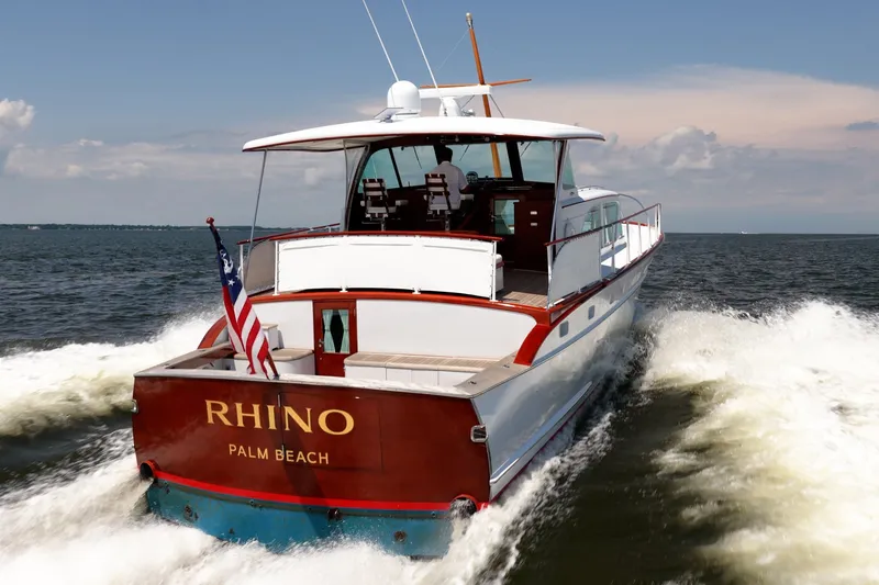 Slide: The Image of 1958 Rybovich 54 Yachtfish cruising on open water, rear view with American flag. - 22