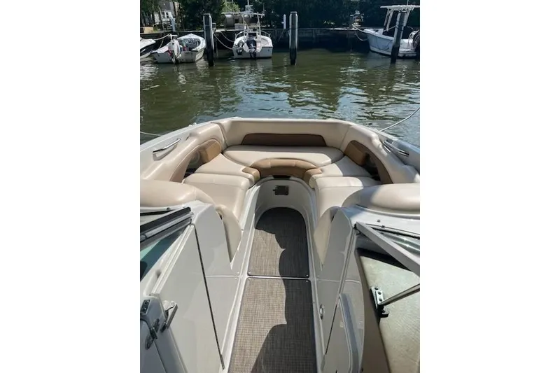 Slide: The Image of 2015 Crownline Eclipse E6 boat interior with beige seating, docked at a marina. - 3