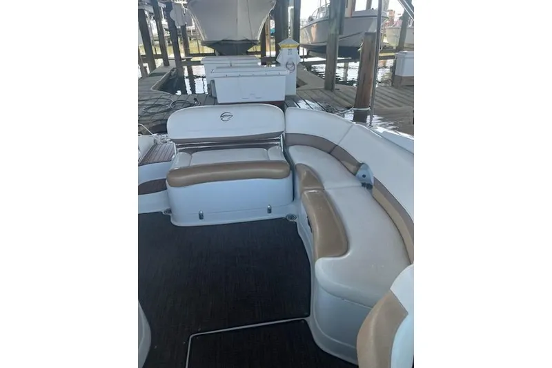 Slide: The Image of 2015 Crownline Eclipse E6 boat interior with white and tan seating under a dock. - 4