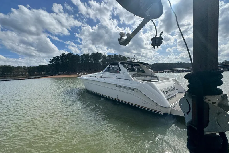 Slide: The Image of 1996 Sea Ray 500 Sedan Bridge yacht docked on a sunny day with cloudy sky. - 1