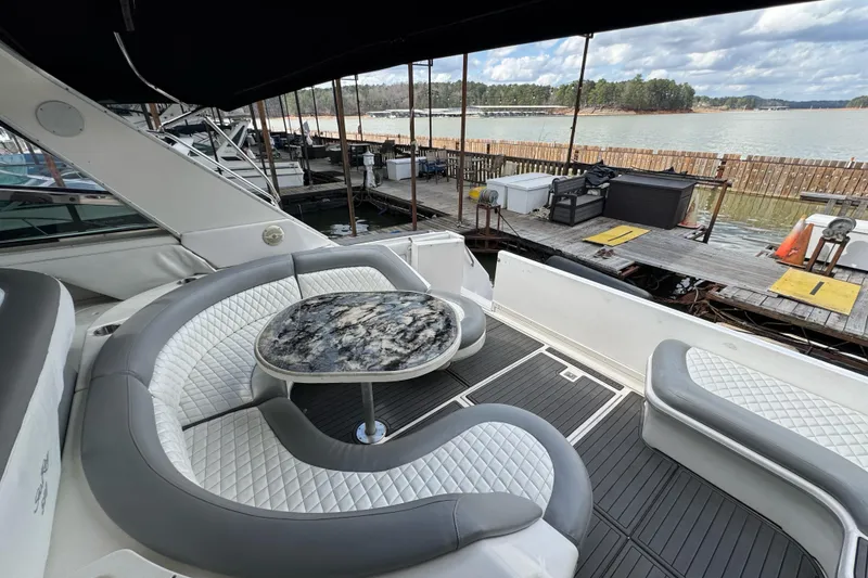 Slide: The Image of 1996 Sea Ray 500 Sedan Bridge yacht with elegant seating and marble table, docked by the water. - 11