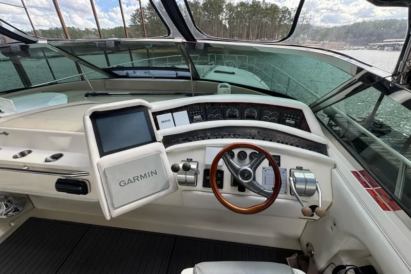 Slide: The Image of 1996 Sea Ray 500 Sedan Bridge helm with Garmin navigation system and wood-accented steering wheel. - 14