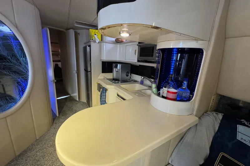 Slide: The Image of 1996 Sea Ray 500 Sedan Bridge interior with kitchenette, bar area, and modern amenities. - 20