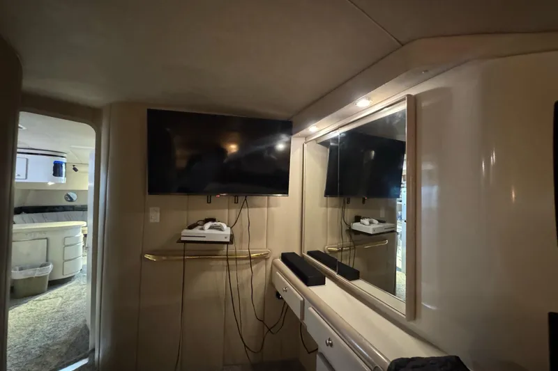 Slide: The Image of Interior of 1996 Sea Ray 500 Sedan Bridge with TV and mirror setup. - 26