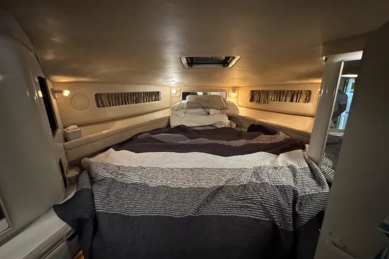 Slide: The Image of 1996 Sea Ray 500 Sedan Bridge cabin interior with cozy bedding and ambient lighting. - 27