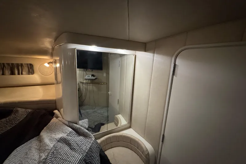 Slide: The Image of 1996 Sea Ray 500 Sedan Bridge interior cabin with bed, mirror, and TV. - 28