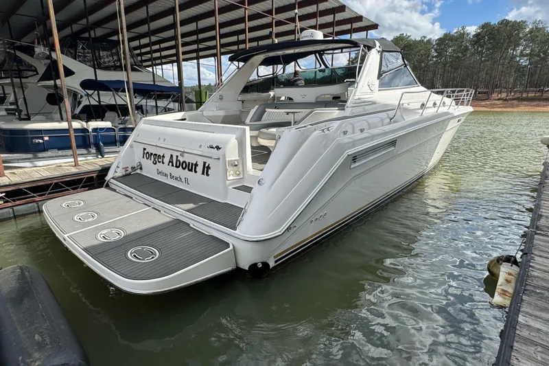 Slide: The Image of 1996 Sea Ray 500 Sedan Bridge yacht docked, rear view, named "Forget About It." - 3