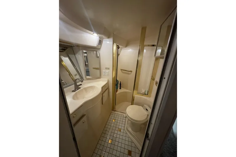 Slide: The Image of Bathroom interior of 1996 Sea Ray 500 Sedan Bridge yacht, featuring sink and toilet. - 30