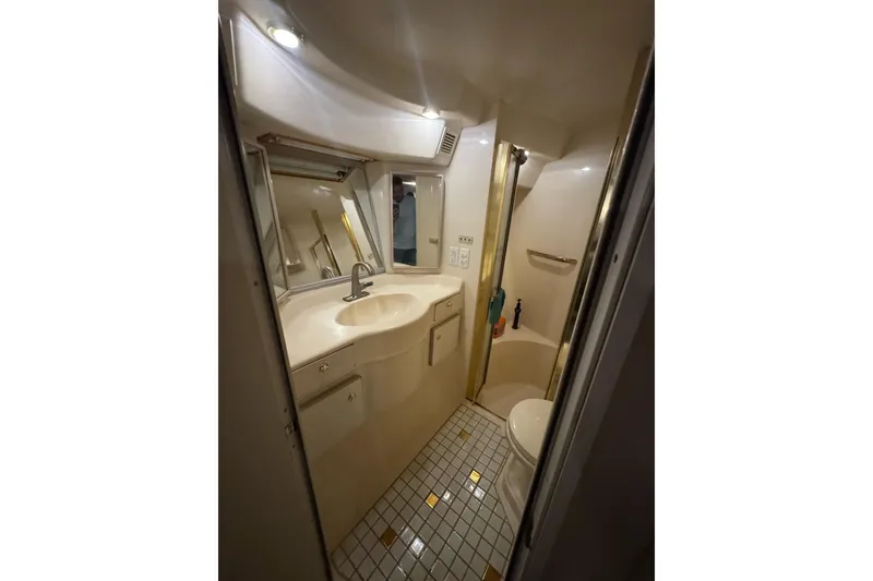Slide: The Image of Bathroom interior of 1996 Sea Ray 500 Sedan Bridge yacht, featuring sink and shower. - 31