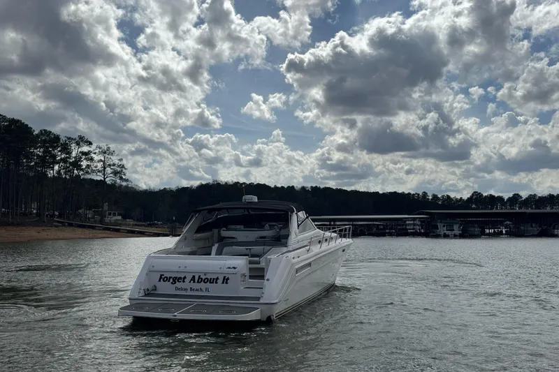 Slide: The Image of 1996 Sea Ray 500 Sedan Bridge yacht on a lake under cloudy skies. - 6