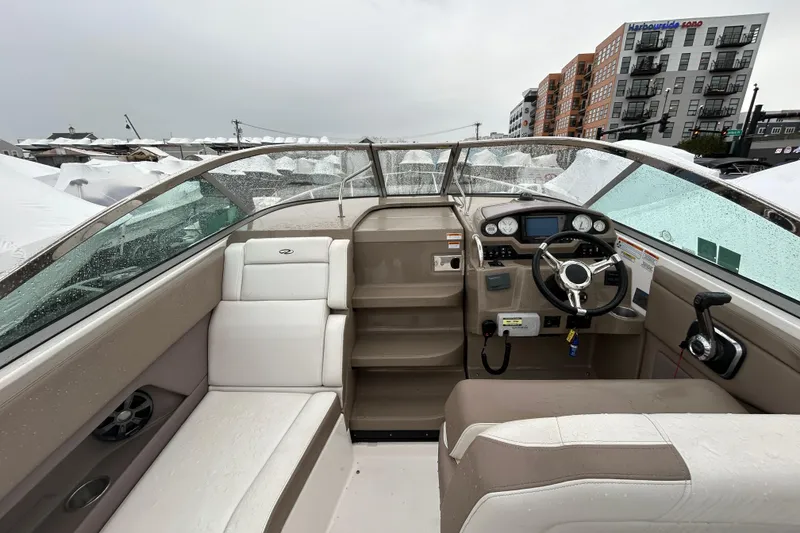 Slide: The Image of 2017 Regal 28 Express boat interior with steering wheel and seating, docked near buildings. - 10