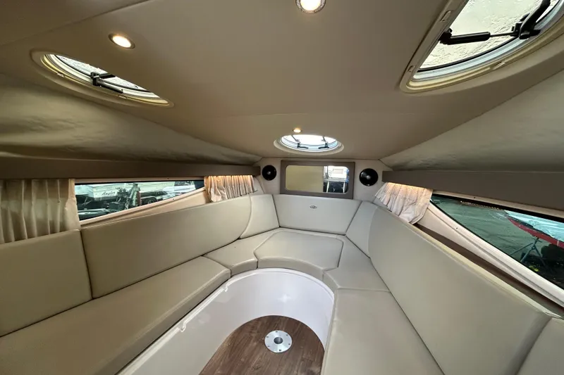 Slide: The Image of Interior of 2017 Regal 28 Express boat with beige seating and circular windows. - 12