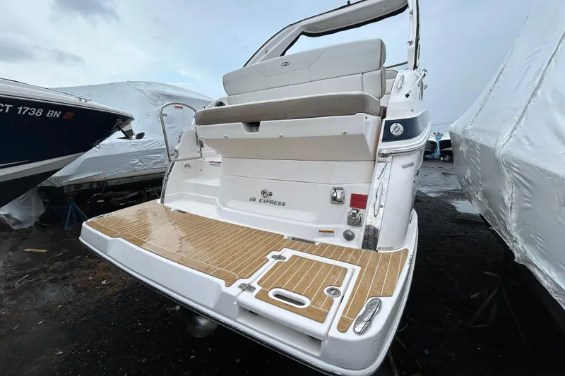Slide: The Image of 2017 Regal 28 Express boat with teak swim platform, docked outdoors. - 2