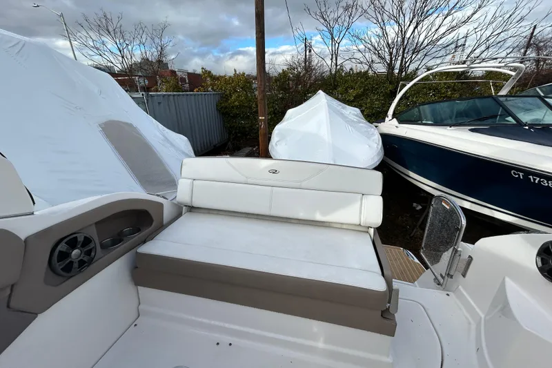 Slide: The Image of 2017 Regal 28 Express boat interior with white seating, parked outdoors. - 7