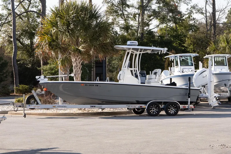 The Image of 2024 Pathfinder 2500 Hybrid boat on trailer, parked near palm trees. - 1