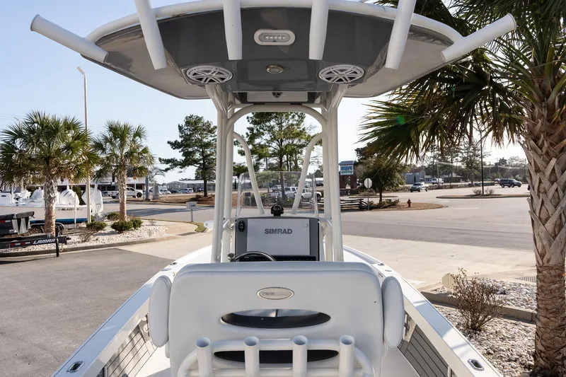 Slide: The Image of 2024 Pathfinder 2500 Hybrid boat with T-top, parked near palm trees. - 7