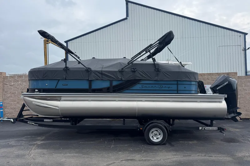 Slide: The Image of 2026 South Bay S222E pontoon boat on trailer, covered and parked outdoors. - 17