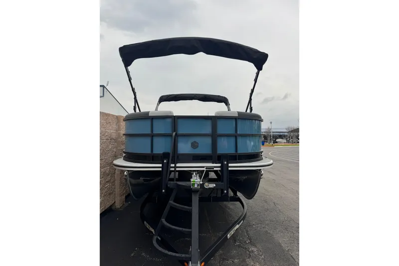 Slide: The Image of 2026 South Bay S222E pontoon boat with canopy, parked on a trailer. - 3