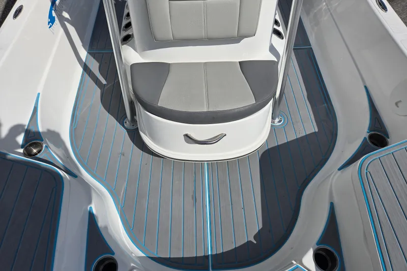 Slide: The Image of 2022 Aquasport 244 Bay boat interior with gray and blue deck, cushioned seating. - 10