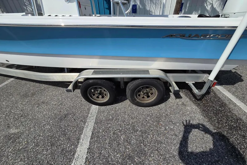 Slide: The Image of 2022 Aquasport 244 Bay boat on trailer, parked in a lot. - 11