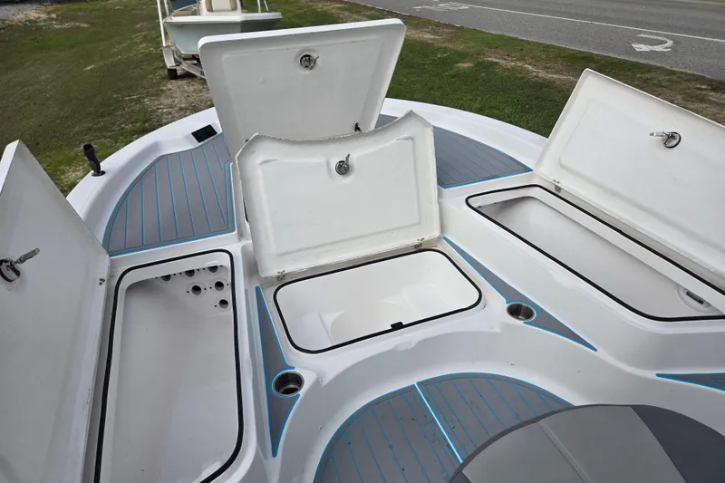 Slide: The Image of 2022 Aquasport 244 Bay boat with open storage compartments on deck. - 16