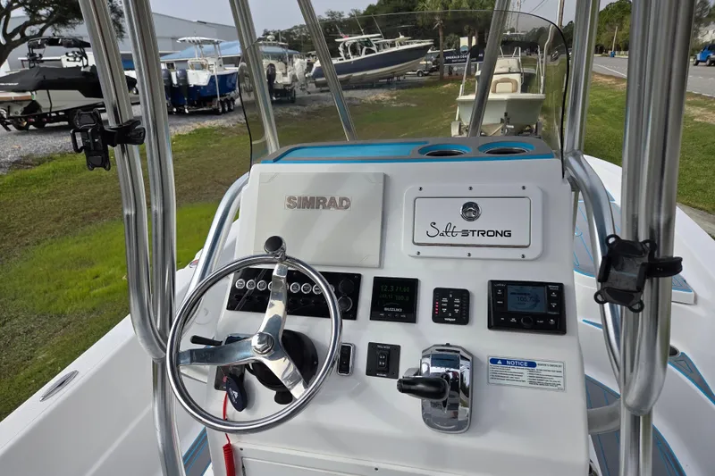 Slide: The Image of 2022 Aquasport 244 Bay boat dashboard with steering wheel and navigation controls. - 18