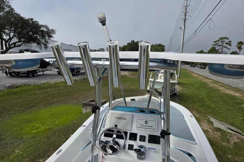 Slide: The Image of 2022 Aquasport 244 Bay boat with rod holders and steering console, parked outdoors. - 19