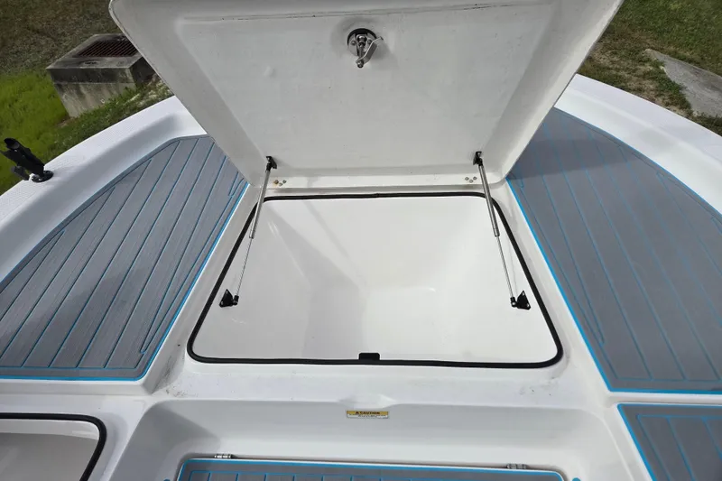 Slide: The Image of 2022 Aquasport 244 Bay boat storage compartment with open hatch and gray-blue deck. - 20