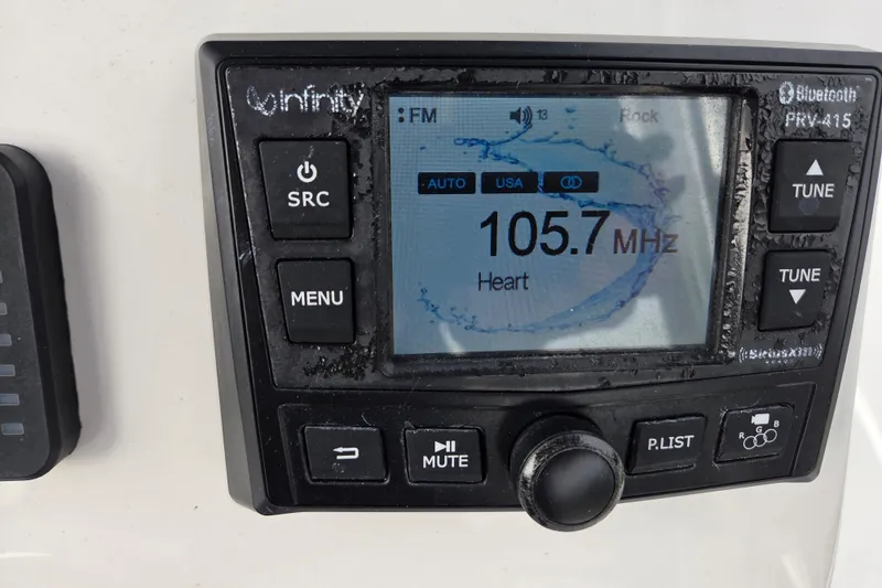 Slide: The Image of Boat radio display on 2022 Aquasport 244 Bay, tuned to 105.7 MHz. - 27
