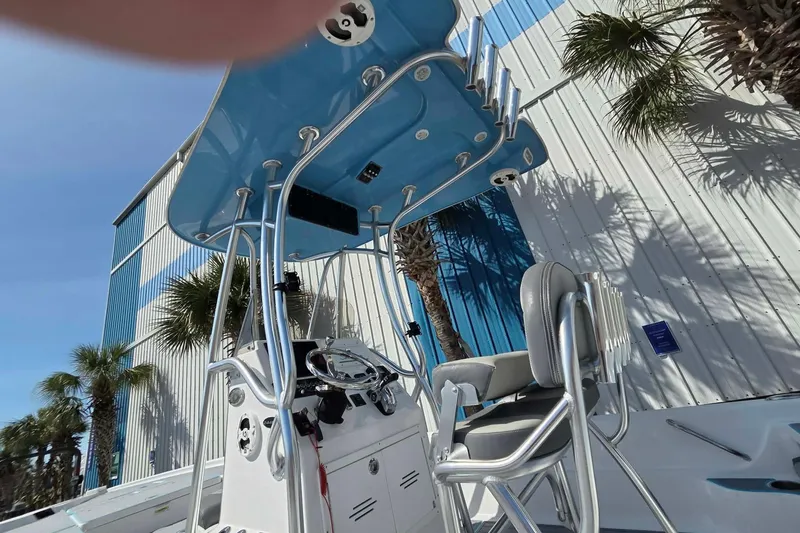 Slide: The Image of 2022 Aquasport 244 Bay boat with T-top and console, outdoors near palm trees. - 8