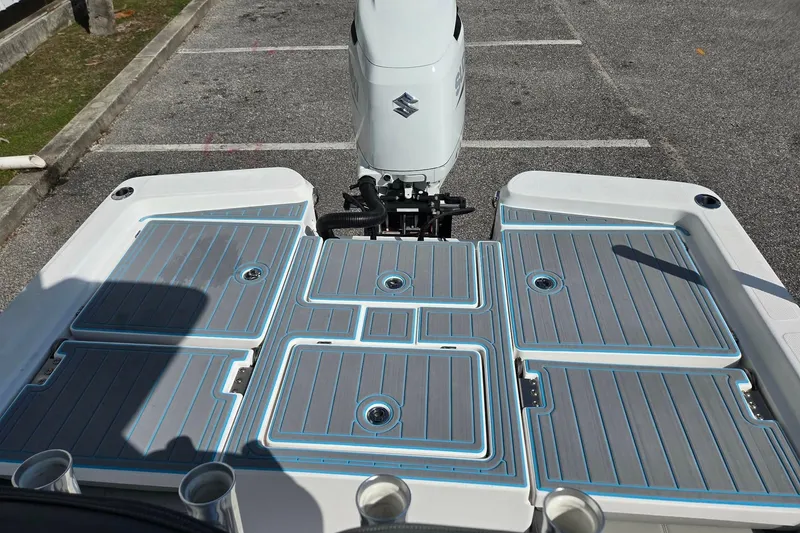 Slide: The Image of 2022 Aquasport 244 Bay boat deck with Suzuki outboard motor in parking lot. - 9