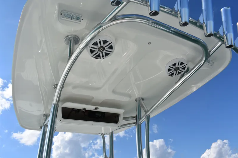 Slide: The Image of 2023 Dorado 25 boat T-top with speakers and rod holders against blue sky. - 15