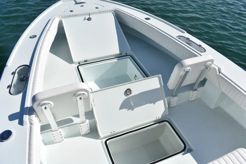 Slide: The Image of 2023 Dorado 25 boat interior with open storage compartments on calm water. - 8