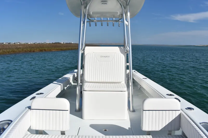 Slide: The Image of 2023 Dorado 25 boat on calm water, featuring sleek white seating and modern design. - 9