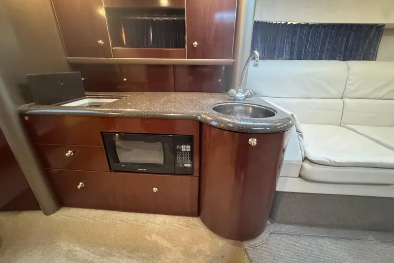 Slide: The Image of 2003 Formula 400 Super Sport interior with kitchenette, featuring sink, microwave, and seating area. - 10