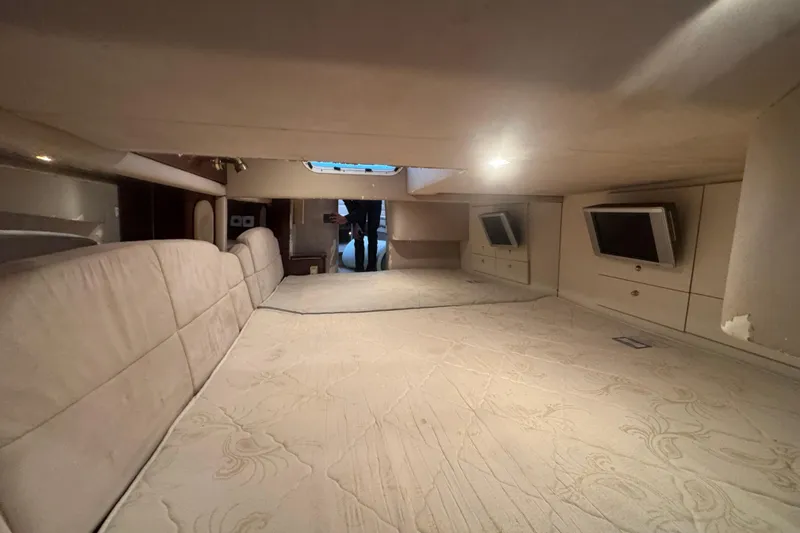 Slide: The Image of Interior cabin of 2003 Formula 400 Super Sport boat with beige upholstery and built-in TVs. - 11