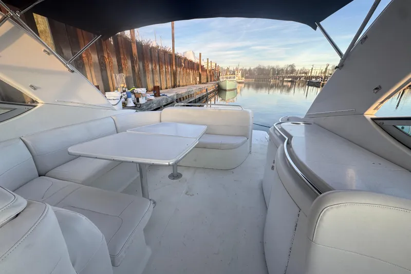 Slide: The Image of 2003 Formula 400 Super Sport yacht interior with white seating and table, docked by calm water. - 3