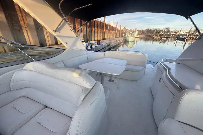 Slide: The Image of 2003 Formula 400 Super Sport yacht interior with white seating and table, docked by calm water. - 6