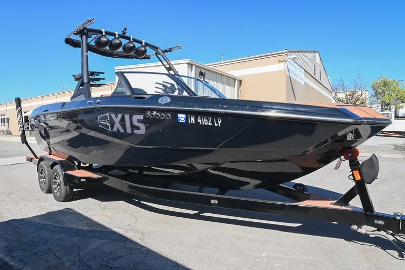 The Image of 2023 Axis A225 boat on trailer, black exterior, parked outdoors. - 1