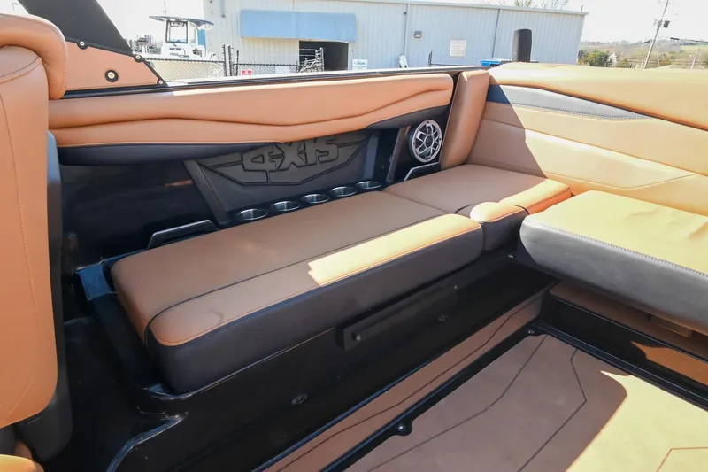 Slide: The Image of 2023 Axis A225 boat interior with tan leather seating and built-in cup holders. - 19