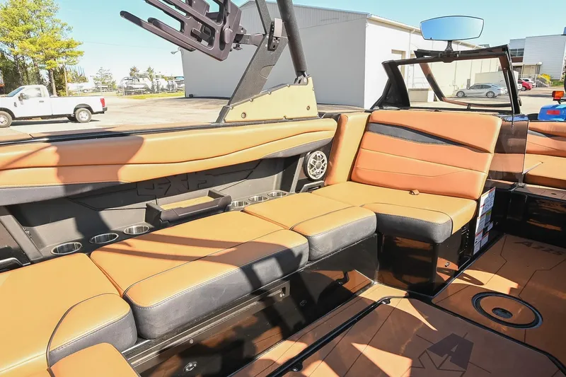 Slide: The Image of 2023 Axis A225 boat interior with tan leather seating and cup holders. - 25