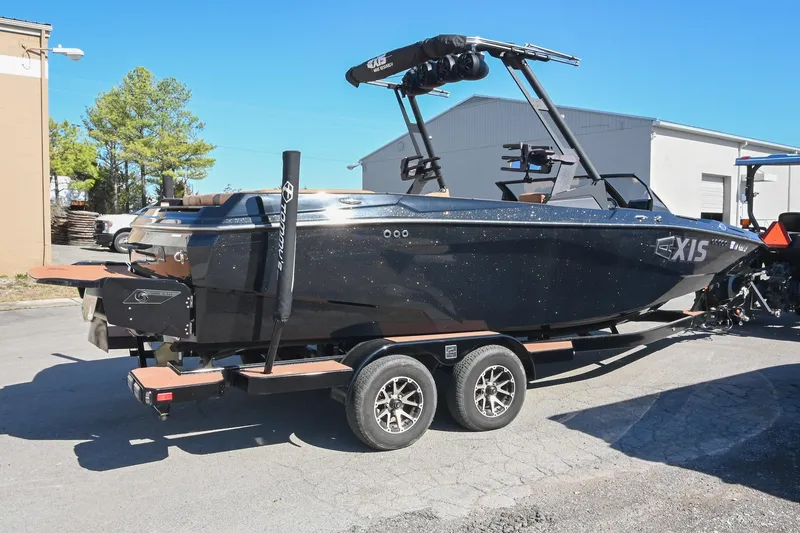 Slide: The Image of 2023 Axis A225 boat on trailer, parked outdoors, featuring sleek black design. - 3