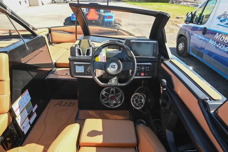 Slide: The Image of 2023 Axis A225 boat interior with tan seats and modern dashboard controls. - 31