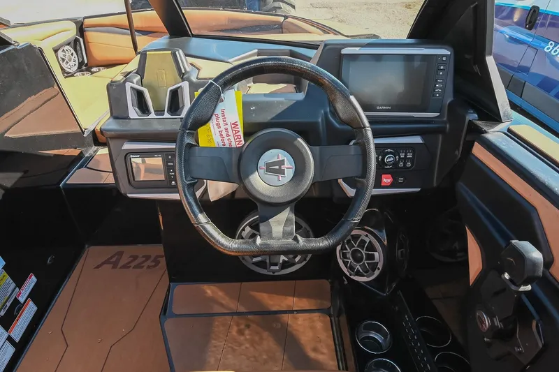 Slide: The Image of 2023 Axis A225 boat dashboard with steering wheel and Garmin display. - 32
