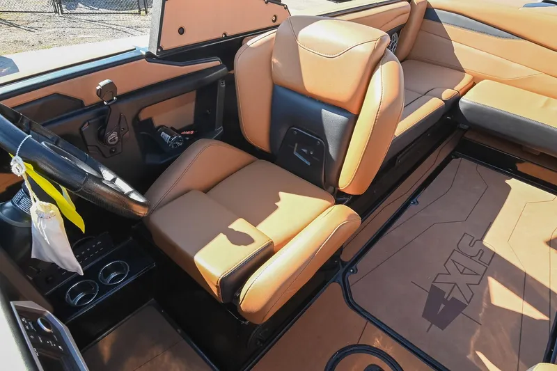 Slide: The Image of 2023 Axis A225 boat interior with tan leather seats and modern dashboard design. - 35